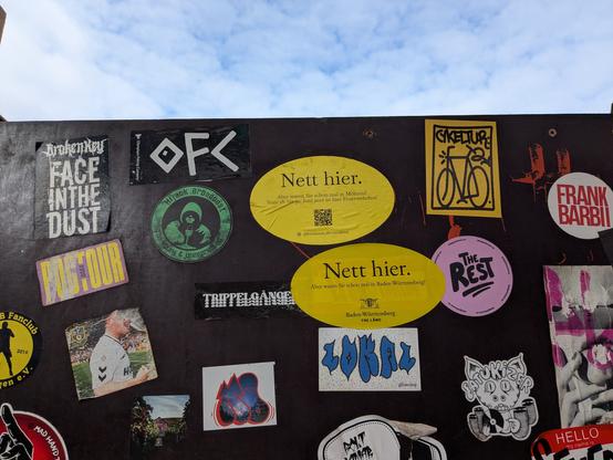 Two Nett Hier stickers from Baden Württemberg on a panel of other stickers