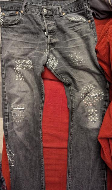 The front of the charcoal jeans. Many more patches of sashiko are visible.