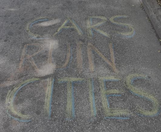 CARS RUIN CITIES written in chalk on the pavement at Atlanta Streets Alive on Peachtree Street and 10th St.