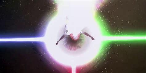 The image depicts a figure emerging from a bright, swirling light at the center, surrounded by colorful beams of light extending outward in a starry background.