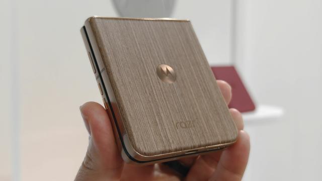 Photo of the wooden back panel of the Motorola Razr Ultra (wood brown) held in front of a white background