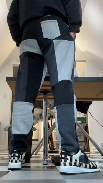 Me in my craft room, wearing color-blocked sweatpants and black-and-white striped sneakers, back view.