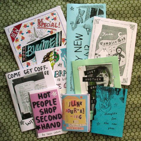 The same 9 zines lying partly over each other. Mostly hand-drawn and collaged cover-art printed in black-and-white and some colours.