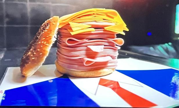 A stack of ham slices topped with sliced cheese that looks like Donald Trump