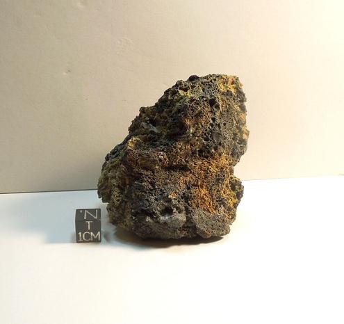 Specimen of Pica Glass shown next to a black centimeter cube.