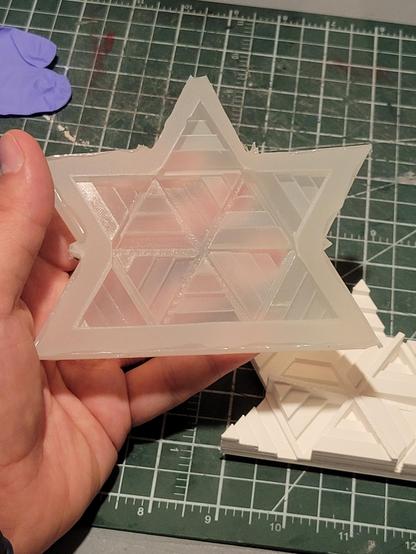 A translucent silicone mold in the shape of a stylized maple leaf, segmented into triangles and stair-stepped.