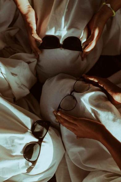 people covered with sheets wearing sunglasses