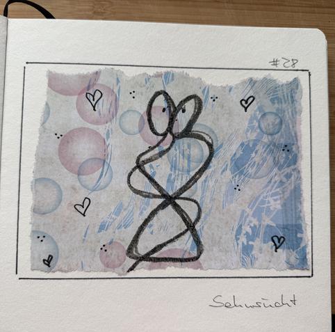 Ein Stück Papier mit blauen und rosa Seifenblasen. Darauf mit Ölkreide Herzen und zwei Menschen in inniger Umarmung.