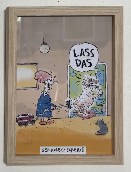A cartoon by cartoonist Ari Plikat with a retired couple. He stands naked in the bathroom by the mirror and wants to brush his teeth, she holds a hoover and sucks his bum cheeks. He exclaims loudly: 'Stop that!' A grey cat observes the scene