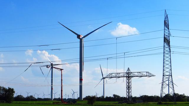 Windkraftanlagen zwischen Stromleitungen auf einer großen Wiese 

© NDR Foto: Peer-Axel Kroeske