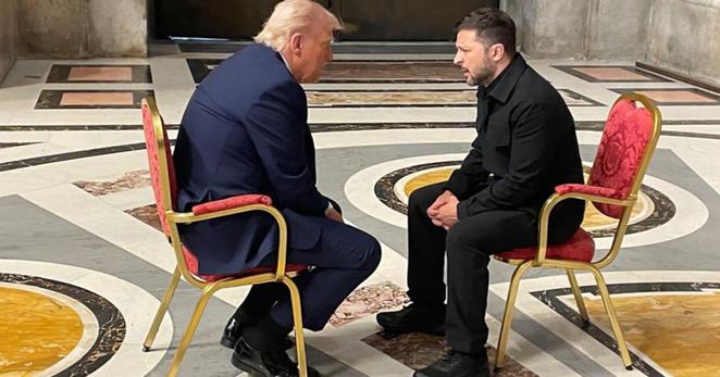Two sitting men engaged in argument, in an otherwise empty room.