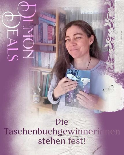Die Autorin Martha Sophie Marcus steht vor einem Bücherregal und hält ihr Taschenbuch »Demon Deals« in den Händen. Aufschrift: Demon Deals. Die Gewinnerinnen stehen fest.