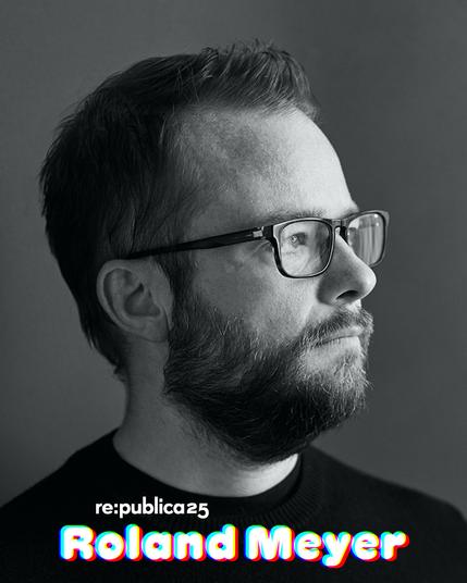 Foto von Roland Meyer. Er trägt kurze Haare und Brille und schaut nach rechts. Das Bild ist in schwarz/weiß.