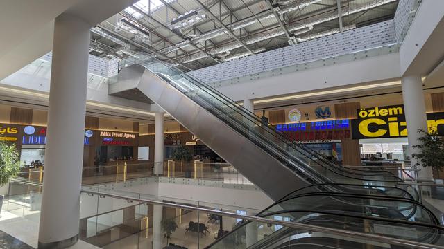 A huge, modern bus terminal with a couple of ticket counters and escalators.