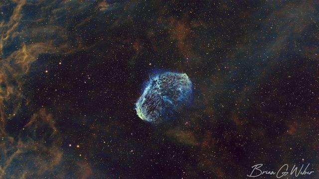Subject: Crescent Nebula (NGC 6888). This version is processed in SHO, meaning Sulfur-2 (naturally red) is mapped to the red channel, H-alpha (naturally red) is mapped to the green channel, and Oxygen-3 (naturally blue) is mapped to the blue channel. This is a less natural than the other HOO image, but highlights the different emissions more clearly as SII and Ha are difficult to distinguish visually.