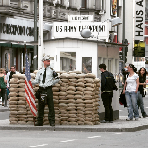 a recreation of Checkpoint Charlie, with a guard hut, sandbags, and armed guard. Complete with gawking tourists