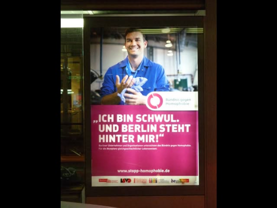bus shelter poster with photo of man and quotation, "Ich bin schwul, und Berlin steht hinter mir!"
