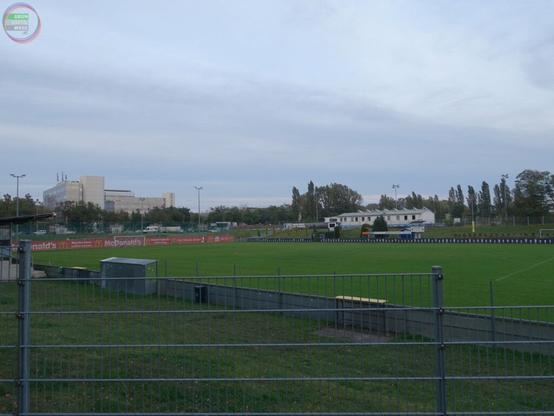 Blick von außen auf einen umzäunten Fußballplatz
