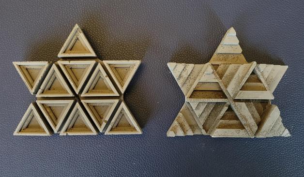 A pair of stylized concrete maple leaves whose geometry cast patterns of light and shadow.