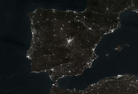 Outline of a continent showing areas with and without power, everything lit up in cities