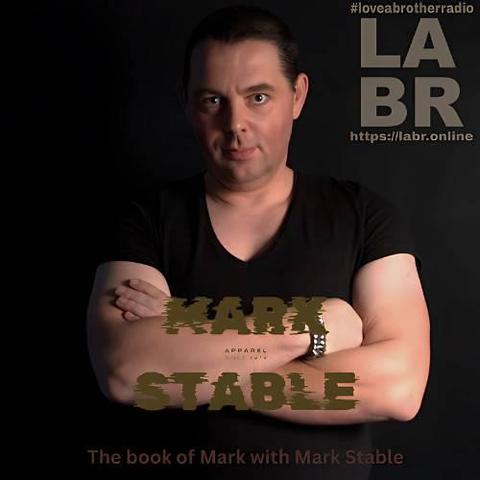Black Background, with a DJ Mark Stable in the centre. Black V-neck t-shirt. hair slicked back. fair skinned. Arms crossed with him looking directly into the camera. The words Mark Stable written across his arms. LABR Logo upper right hand side left hand side of his face. "our right" The Book Of Mark with DJ Mark Stable written on the bottom.