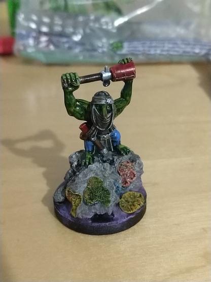 A buff goblin showing his gains from atop a tactical boulder.