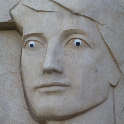 Close-up of the worker's face, with the laugh-out-loud absurdity of googly eyes, added by someone good at climbing bas-relief sculptures.