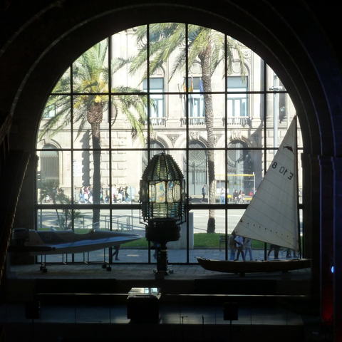 A lighthouse lantern centred in an arched window at the Museu Marítim de Barcelona
