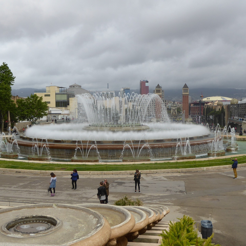 A large, elaborate, circular fountain centred in a grand plaza.