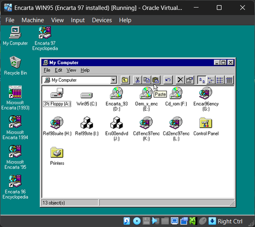 Windows 95 screenshot showing 9 CD-ROM drives, housing Encarta 93, 94, 95, 96, 97 (Deluxe, 2 CDs), 98 Reference Library (DVD), 99 Reference Library (DVD) and 2000 Reference Suite (DVD).