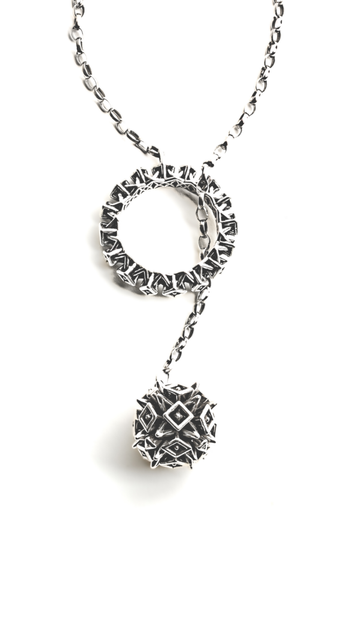 A solid sterling silver lariat necklace by Xover0 photographed on a white background. The necklace is composed of a spiked ball and matching ring soldered to opposite ends of a chunky chain.