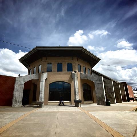 A building with large windows and concrete half-arch things along one side.