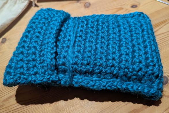Gehäkelte Tasche aus Blau-Grüner Wolle.