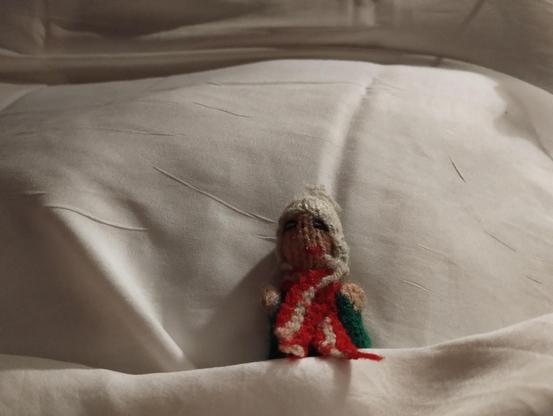 A Peruvian finger puppet, unable to sleep through sheer excitement, takes to his bed.