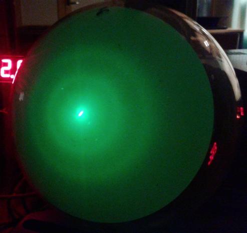Two green glowing circles with gradual edges on a spherical screen, with a bright central point.