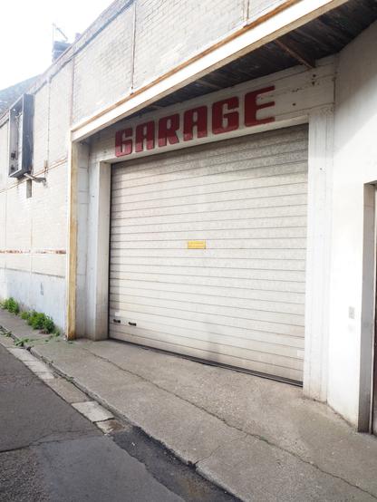 Sign saying Garage, above the door of what is likely a garage.
