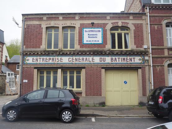 Two signs for a construction company. The bottom one is probably quite old, while the top one is younger – but also old?