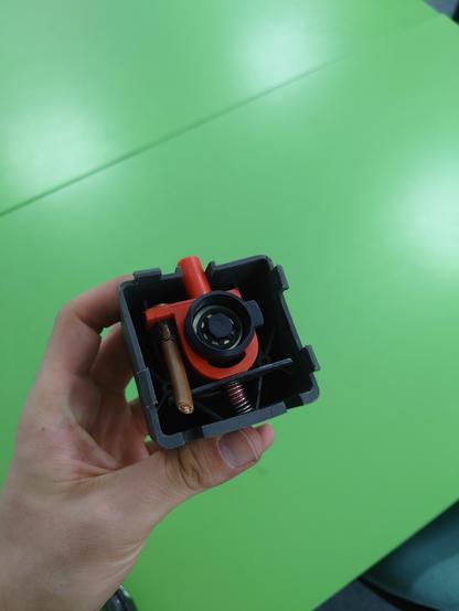 The original battery connector in my hand, showing the underside, the contactors have been removed and visible is the kill switch mechanism.