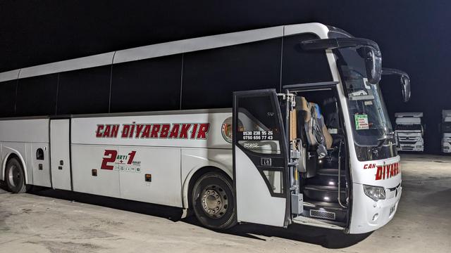 M new bus at a rest area at night time.