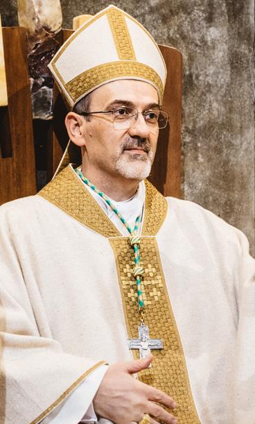 An Italian man with a salt and pepper goatee, and he's all rizzed out in his White And gold vestments