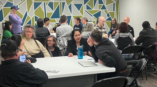 Folks at tables in the Bowness CA talking climate solutions