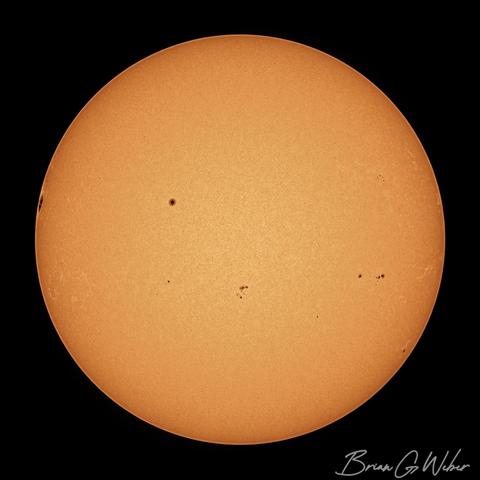 The sun dotted with mostly small sunspots. There is a massive spot lurking on the edge that should come into view tomorrow.