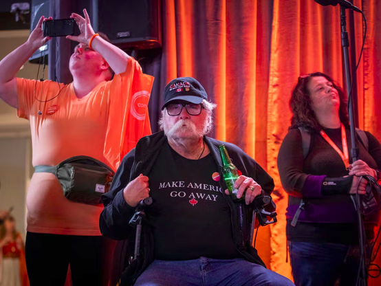 Wearing a cap that reads Canada is Not For Sale and a T-shirt that reads Make America Go Away, a person sits waiting for results at the NDP election night headquarters.

Caption: Supporters watch the federal election results from the NDP election night headquarters in Burnaby, B.C. (Ben Nelms/CBC)