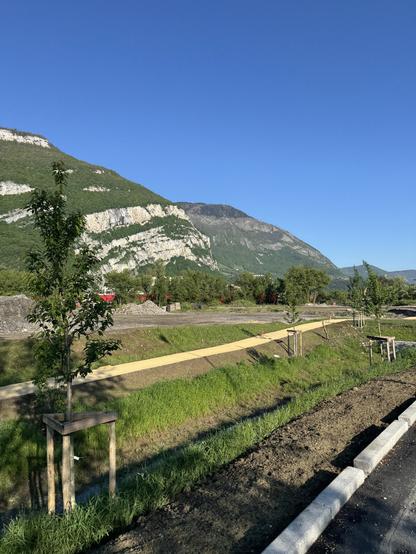 Photo du Vercors avec un beau ciel bleu, avec au premier plan un nouvel espace vert en cours d’installation.