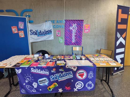Photo du stand Solidaires Informatique à MiXiT, superbement fourni et décoré, sur lequel on peut voir et trouver des brochures et documentations syndicales, ainsi que de magnifiques stickers.