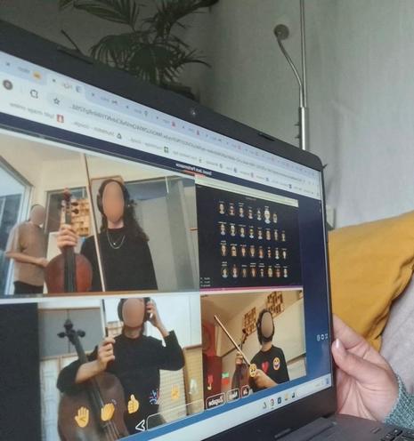 Foto mit einem Laptopbildschirm. Darauf eine FeedBeat-Veranstaltung, bei der verschiedene klassische Musiker gemeinsam musizieren. Dabei das Publikum als Avatare.