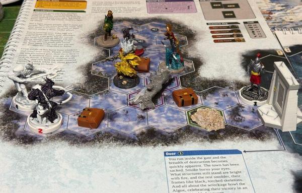 A Frosthaven game in progress, showing painted hero minis (Boneshaper, Banner Spear, Blink Blade and Deathwalker) in the middle, two partially painted enemies to the left, and a painted guard mini to the right. The map is printed in a scenario book and is populated with 3D printed terrain and loot tokens.