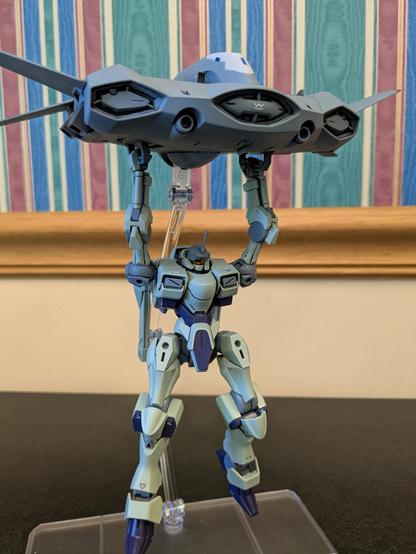 The HG Zowort holding onto the HG Tickbalang (personal transport vehicle). The Tickbalang is on a stand, but the Zowort is holding on without any support from underneath.