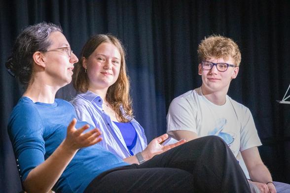 Schüler*innen und Wissenschaftler*innen auf Bühne im Gespräch