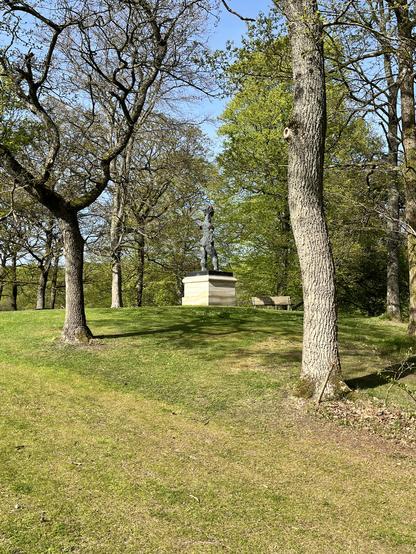 Eine Statue und Bank im Park neben dem Museum. Auf der Bank wird dieser Beitrag geschrieben.